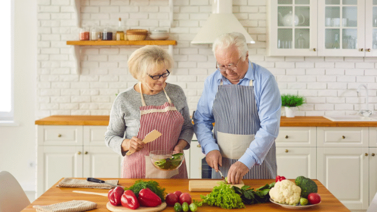 Um casal de idosos preparando uma refeição juntos e felizes em sinal de saúde e Bem Estar