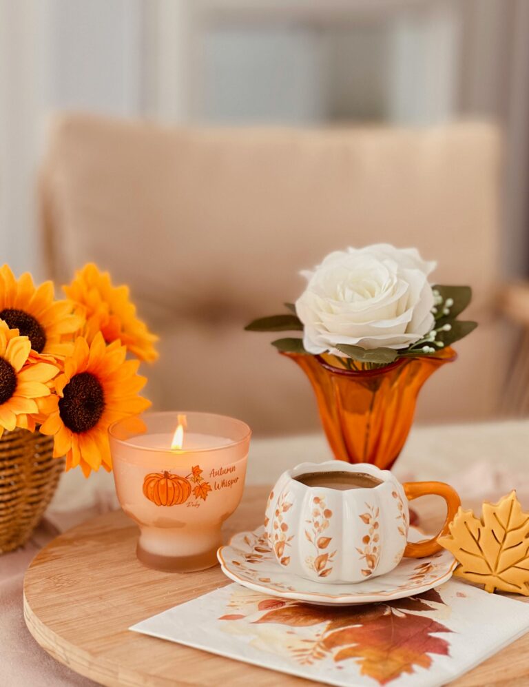 Cena com café, vela e flores sobre mesa de madeira, criando um ambiente acolhedor de gratidão e bem-estar.